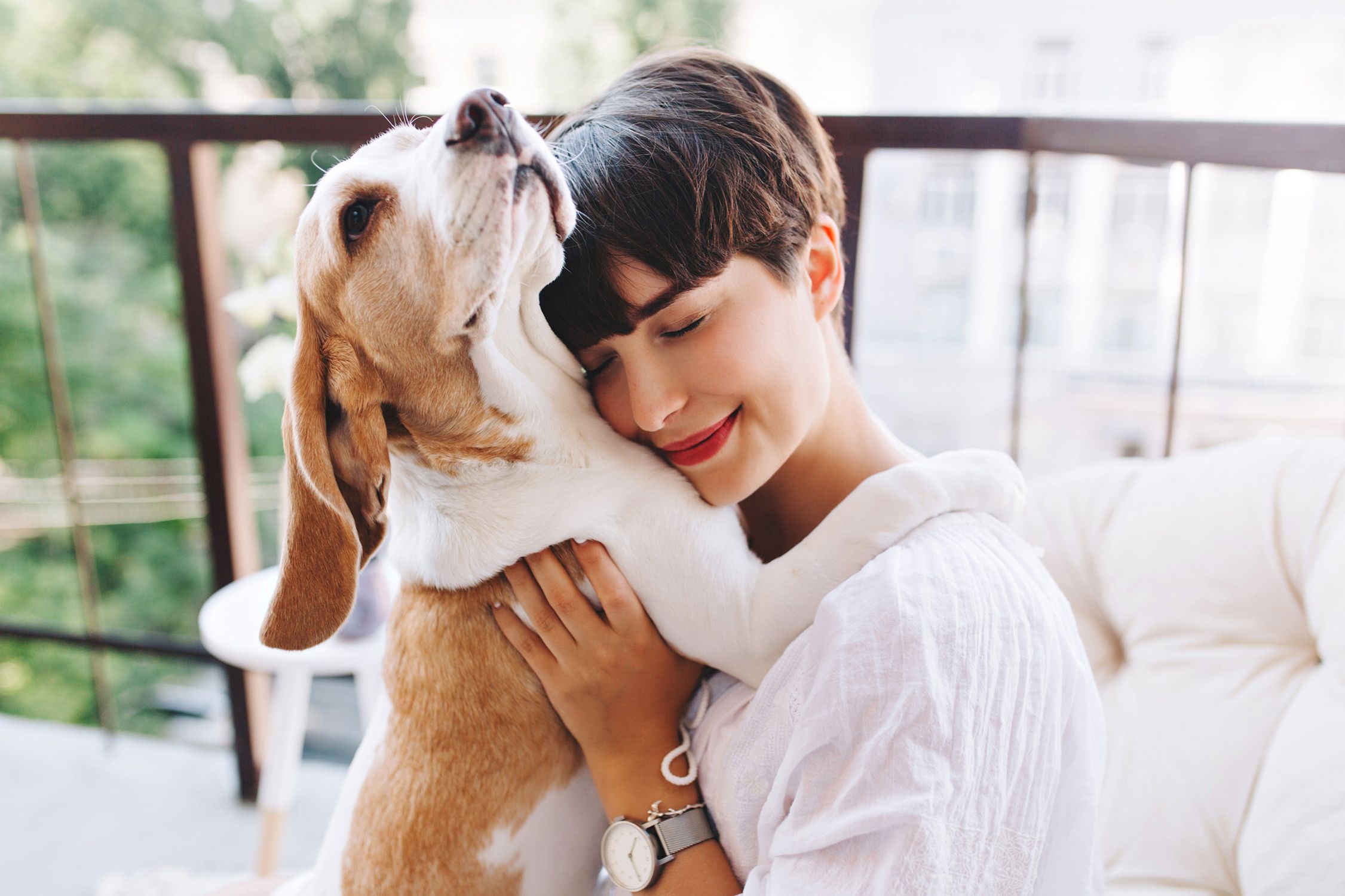 Frau umarmt Hund und lächelt